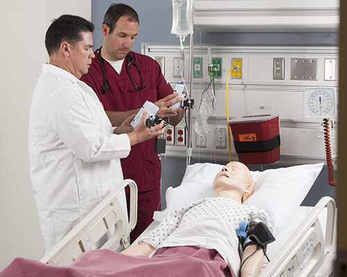 Two Healthcare Workers Learning With A Simulated Patient