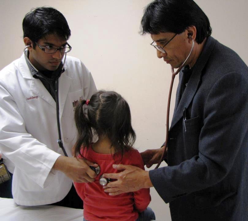 Dr. Juan F. Castro, assistant professor of pharmacy practice, and Jacob George, third-year professional student pharmacist, check a patient in Alton, Texas, during Project SHINE.