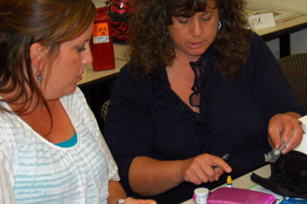 Health Educator Demonstrates Glucose Testing.