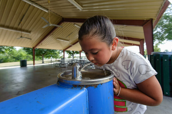 Young Girl Drinking From A Water Fountain.