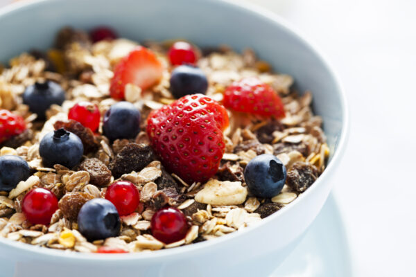 A Bowl Of Granola Cereal, With Berries On Top