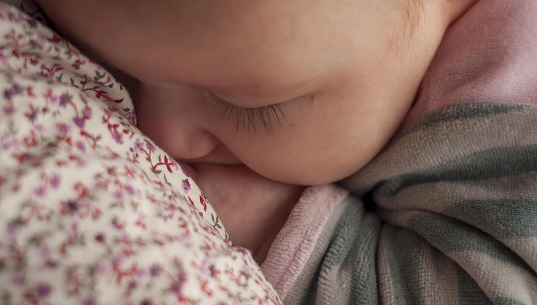 Baby snuggling with mother