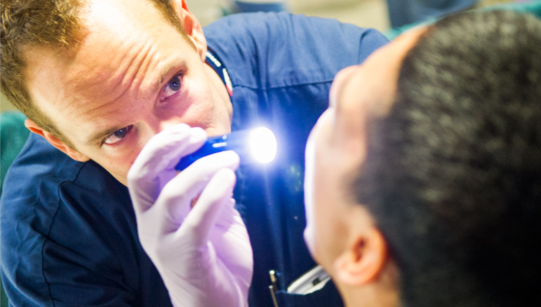 Dentist shinning light into patients mouth