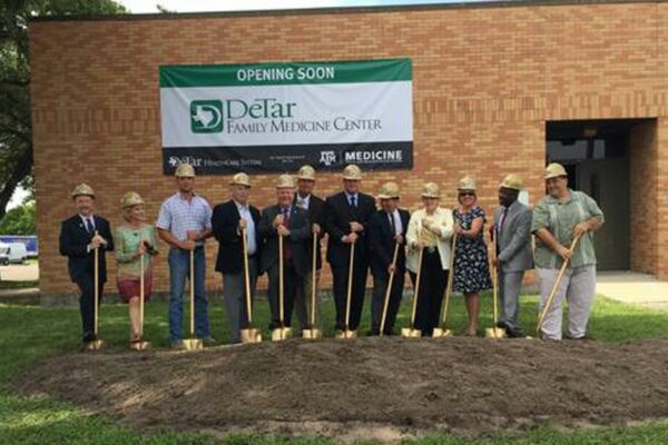 People Holding Shovels With Dirt