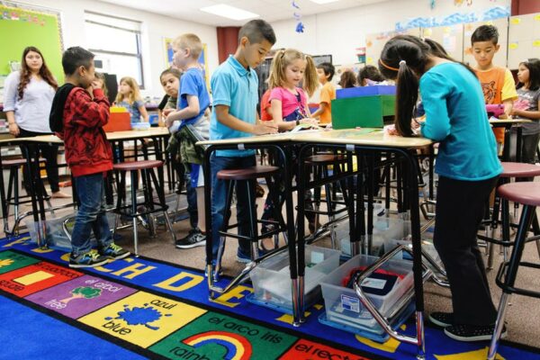 Young Children In A Classroom Using Standing Desks.