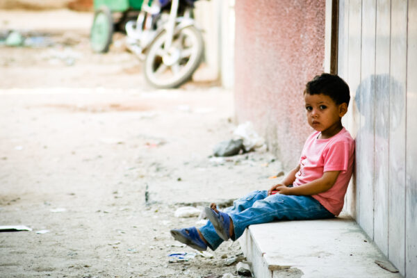 Boy Waiting Outside Building