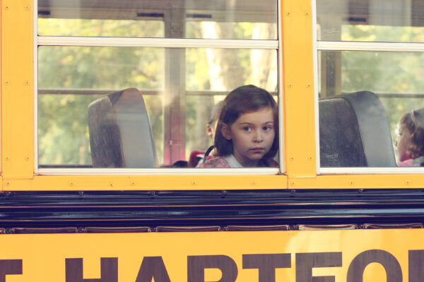 Little Girl Looking Out Of A School Bus Window