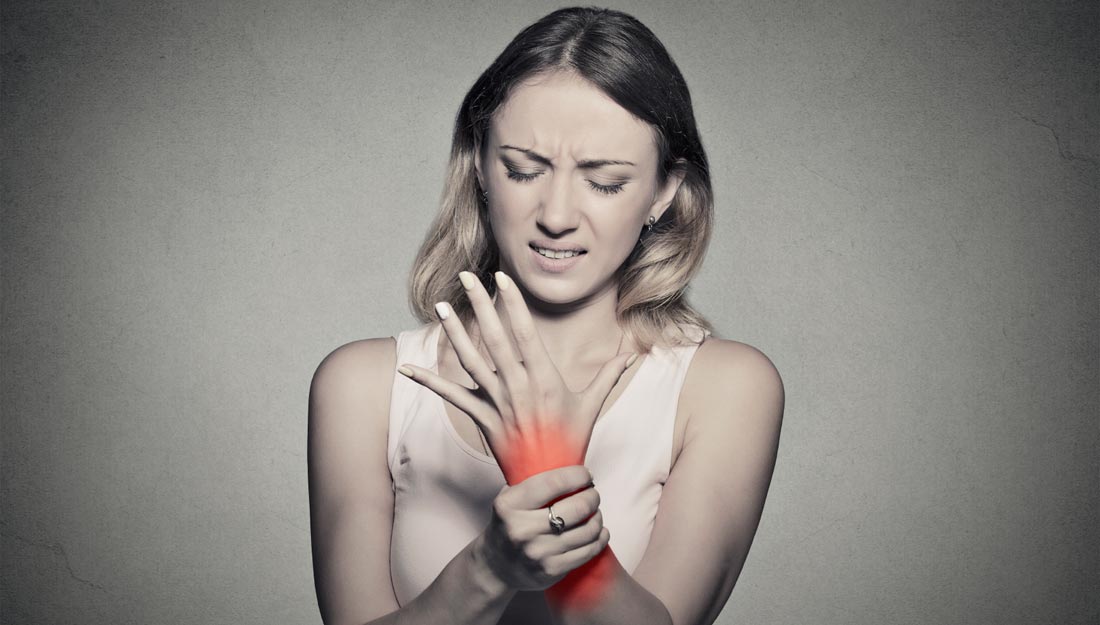 Young woman holding her wrist