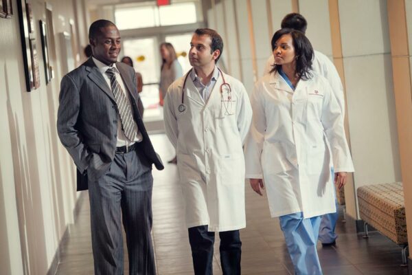 Two Medical Students Listen To Their Professor.