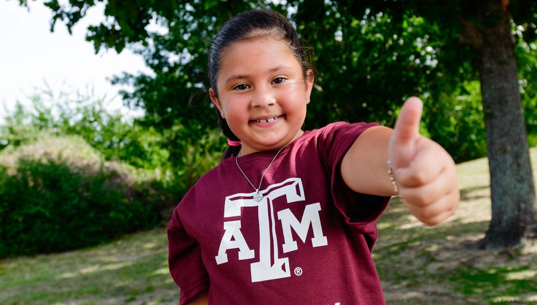 Girl giving gig'em sign