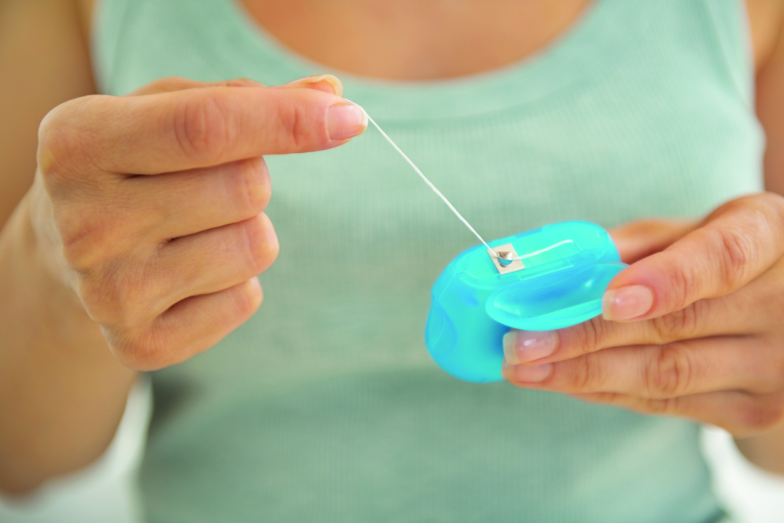 Closeup on young woman flossing