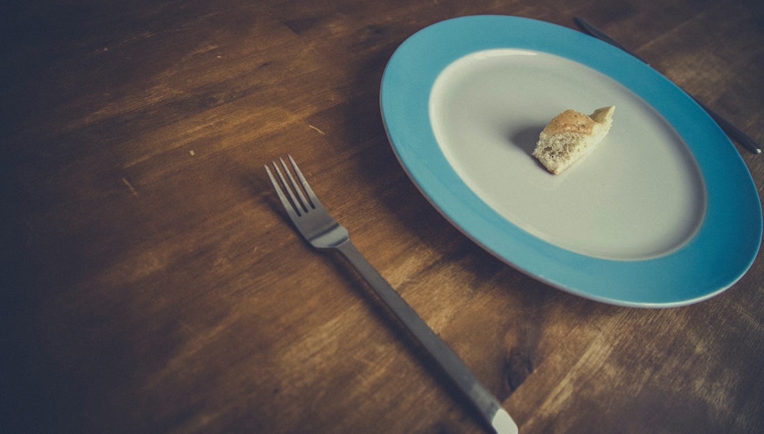 An unusually small piece of bread sits on a plate.