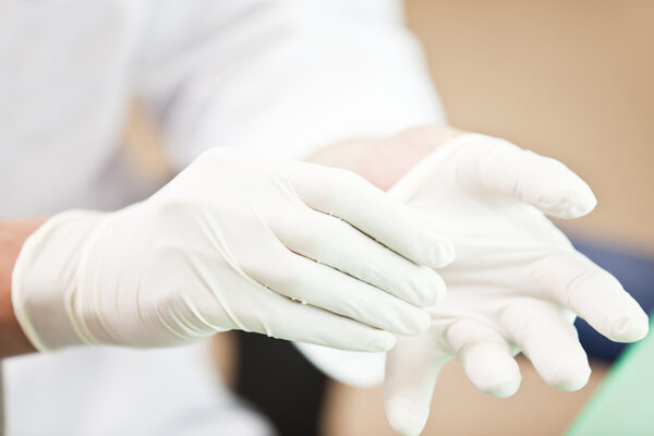 Doctor Putting On Examination Gloves