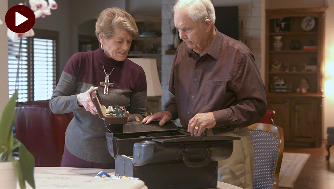 Two people looking through medical bag in living room.