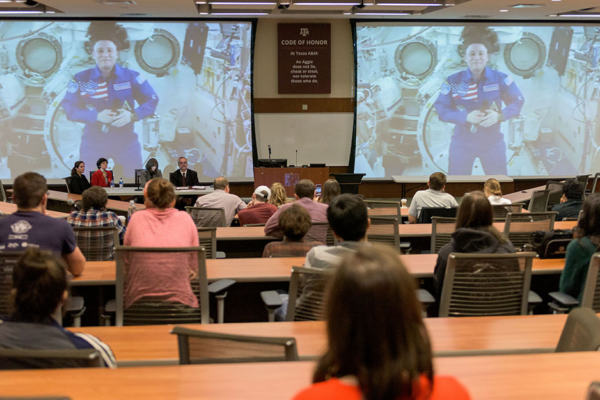 From The ISS, Chancellor Speaks From A Livestream To A Room Full Of Students.