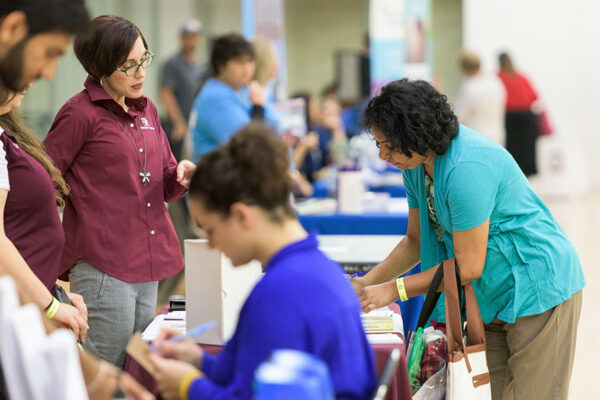 Health Educators Talk With Participants At A Community Health Event.