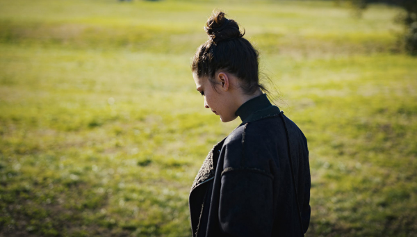 Young woman looking down and away with her back towards the camera