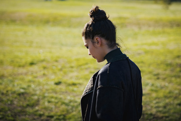 Young Woman Looking Down And Away With Her Back Towards The Camera