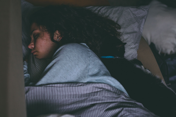 Woman Asleep In A Bed With A Cat. Nighttime Asthma