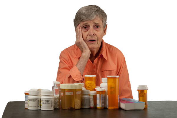 An Elderly Woman With Medications Looking Overwhelmed