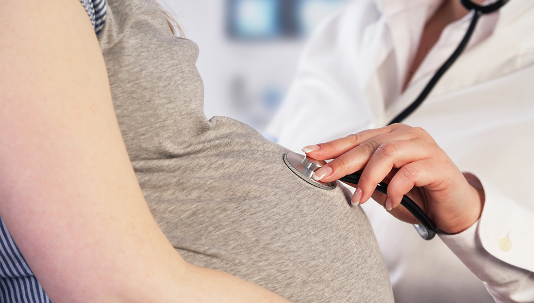 Stillbirth research. Doctor examining a pregnant woman, post stillbirth.