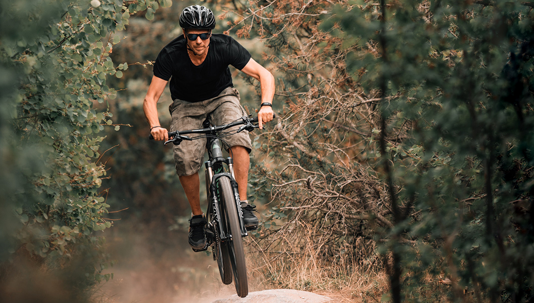 Top 5 injuries and illnesses of the summer-biking-a man is riding a bike through the trees