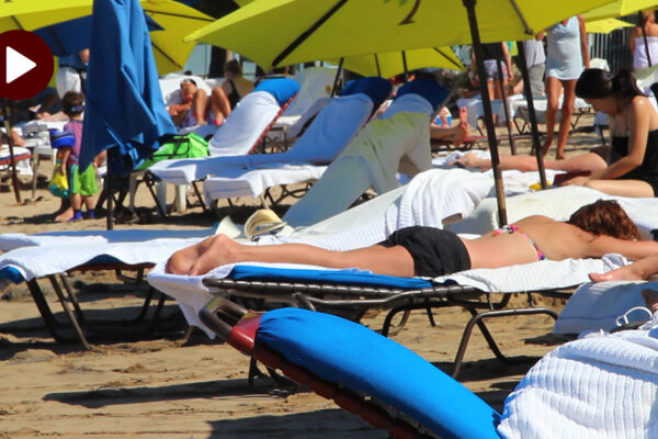 How To Use Sunscreen Properly - An Image Of Sunbathers On A Beach