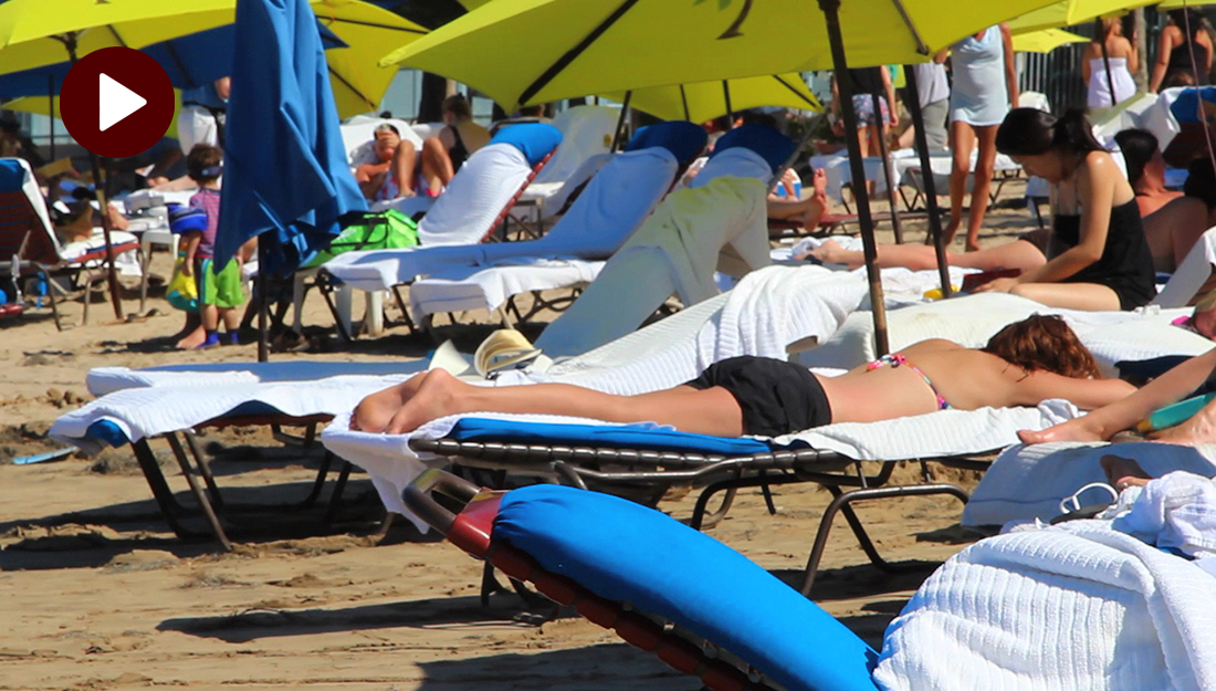 How to use sunscreen properly - an image of sunbathers on a beach