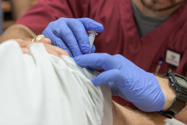 Vaccines_Acetaminophen_immune Response_A Nurse Administers A Vaccine On A Patient's Shoulder