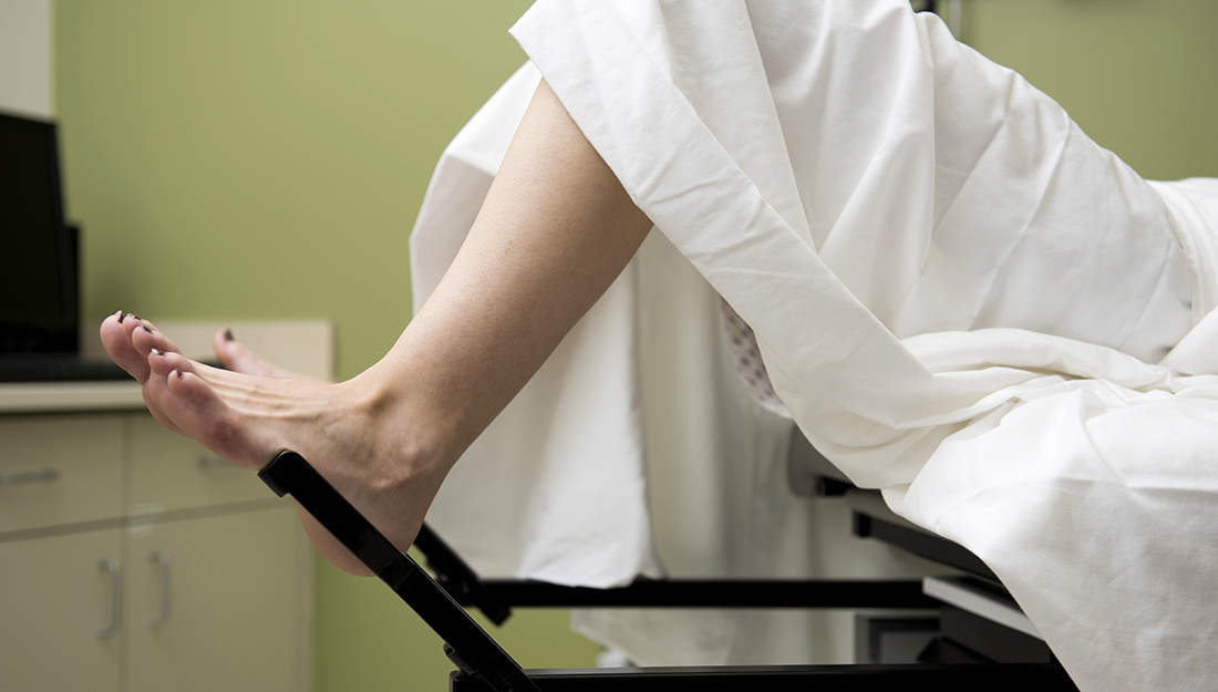 A woman is lying down with her feet in an elevated position