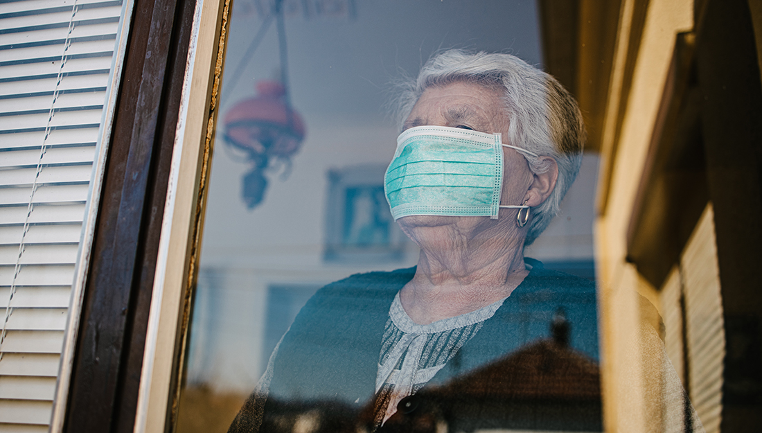 Close-up picture of an old woman in self-isolation stares anxiously