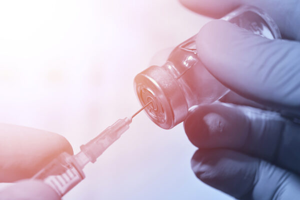 Closeup Of Vaccine Bottle With Syringe And Needle For Immunizati