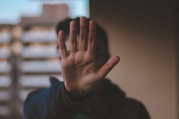 Person Holding Up Hand To Signal Stop