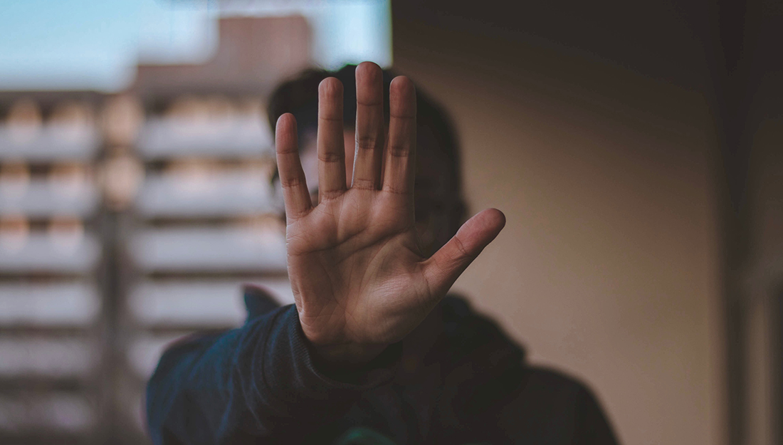 Person holding up hand to signal stop