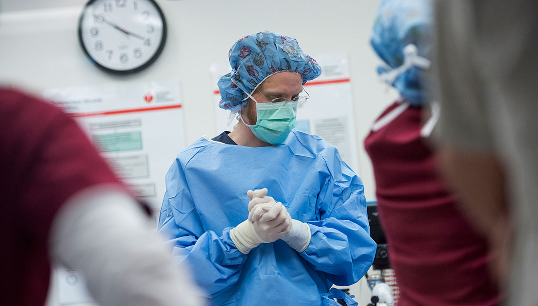 physician in medical mask, cap, cloves and gown