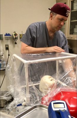 Texas A&amp;M School of Public Health graduate, Maj. Douglas Ruhl, secures plastic around PVC pipe on the prototype for the COVID-19 Airway Management Isolation Chamber (CAMIC)