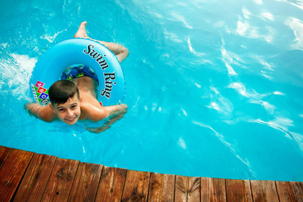 Boy Floating In Pool With Water Ring