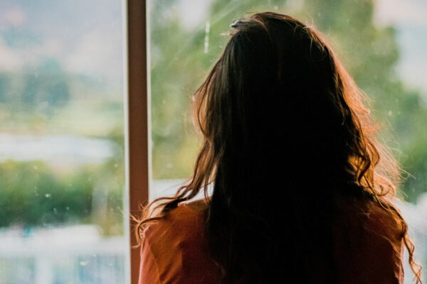 Woman With Dark Hair Looking Out A Window