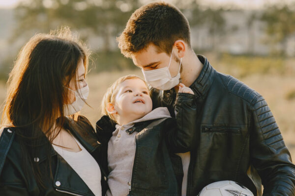 Family Of Three Wearing Face Coverings Outdoors