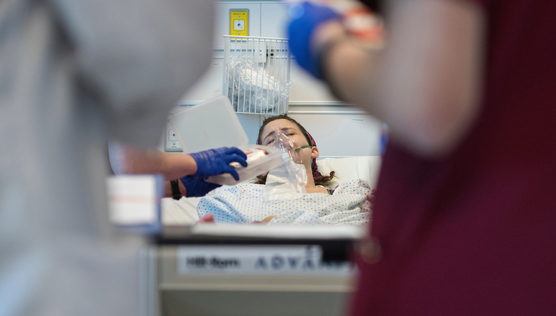 person in hospital bed receiving medical intervention