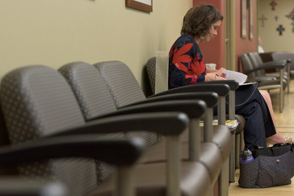 Woman Sitting In Clinic Waiting Room