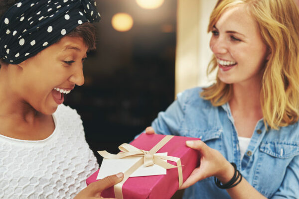 Young Woman Giving A Friend A Surprise Gift