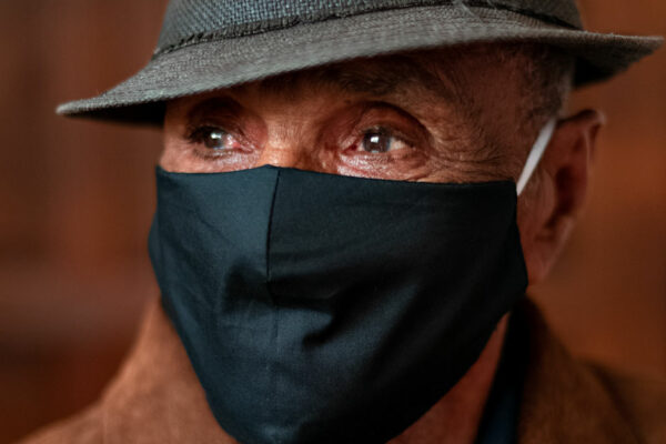 Older Man Wearing A Hat And Face Covering