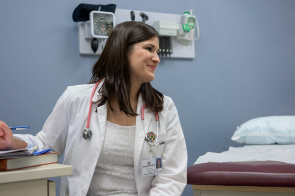 Graduate Nursing Student Sits In A Clinic Exam Room