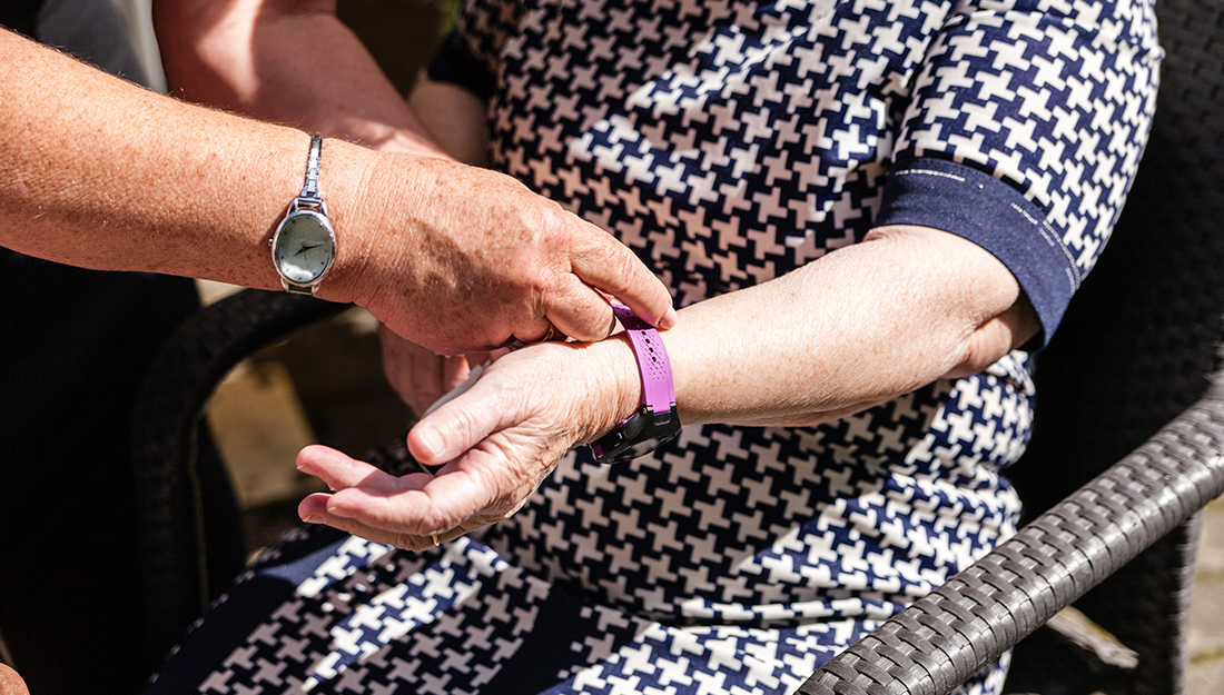 old womans is having wearable device smart watch in care home retirement house.