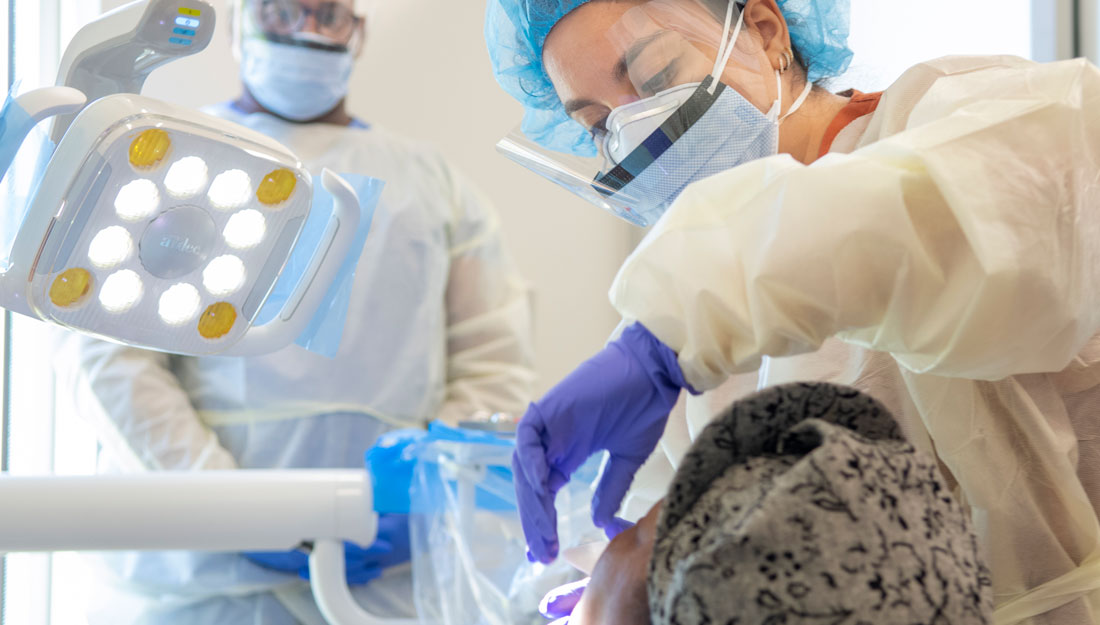 graduate dental students assists professor at an off-site clinic