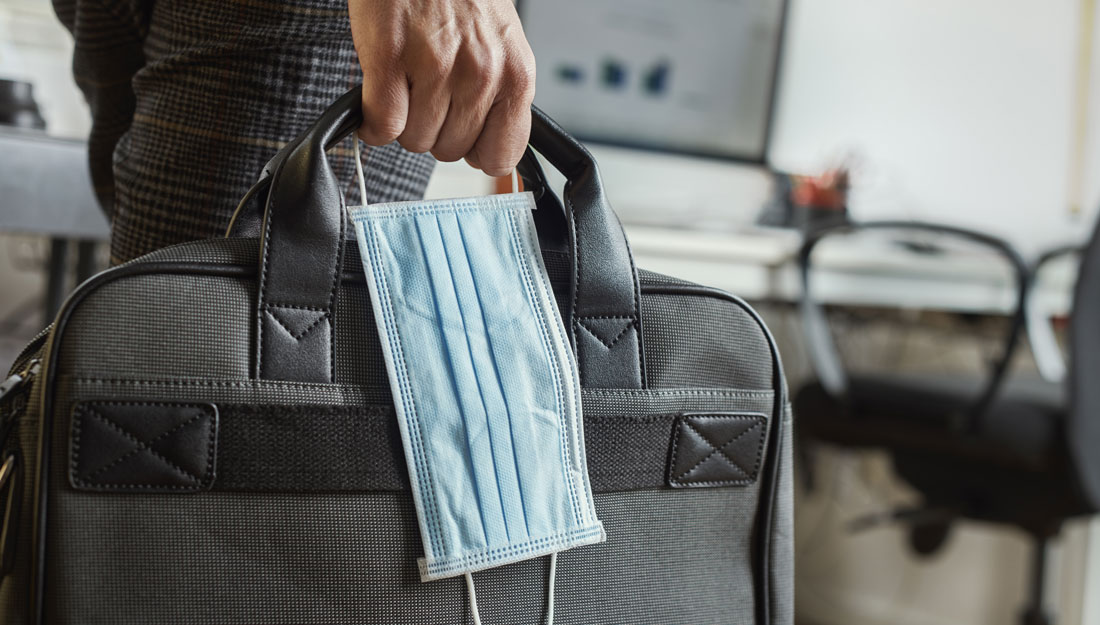 man with a briefcase and a surgical mask