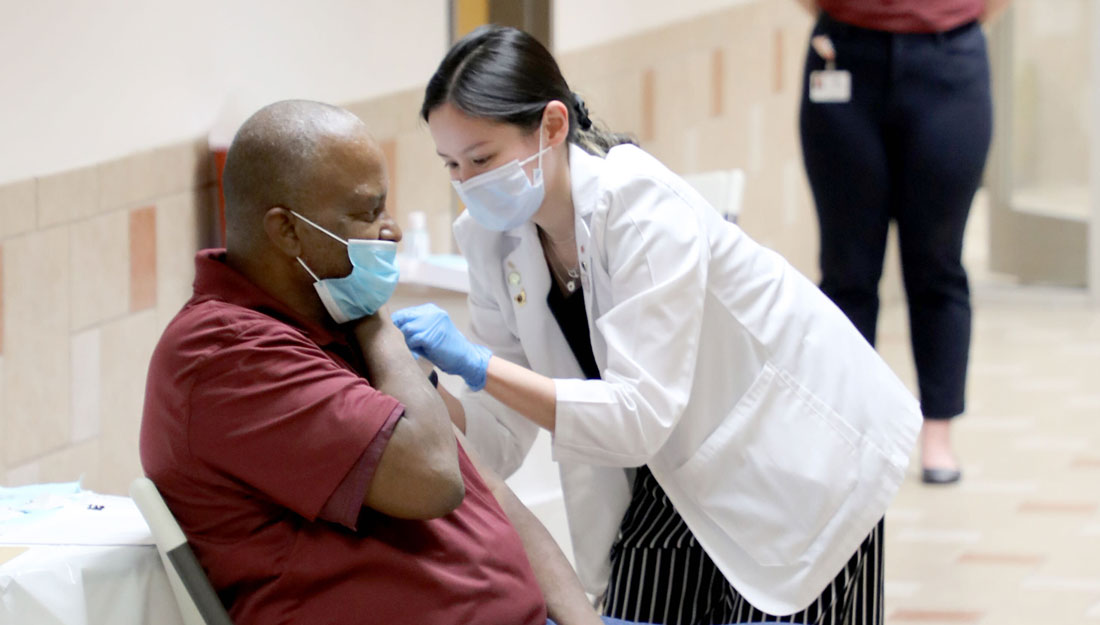 pharmacy student administers a COVID-19 vaccine