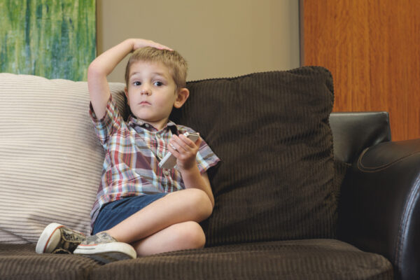 Child On Couch Playing With Cell Phone