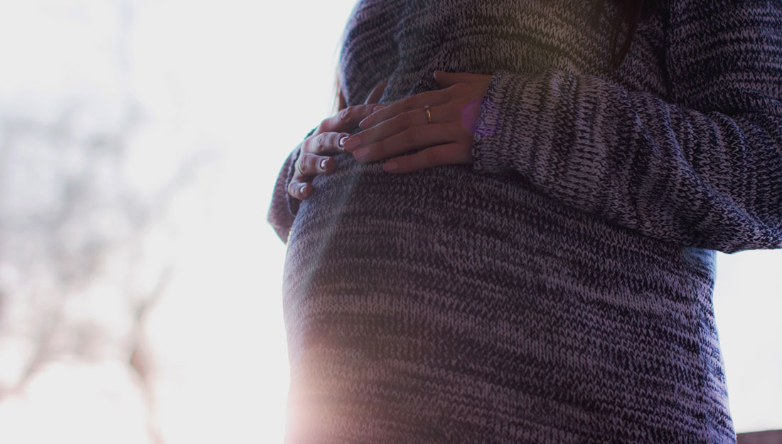 pregnant woman stands outside